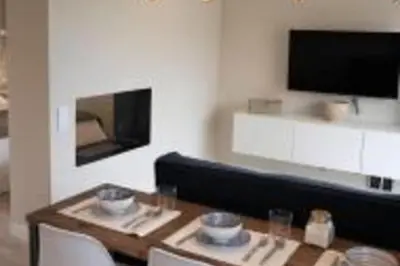 a living room with a table and a tv at Lovely Sea view Apartment in Gava in Gavà