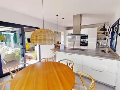a kitchen with a wooden table and chairs at Premium Habitat La Plana in Argentona
