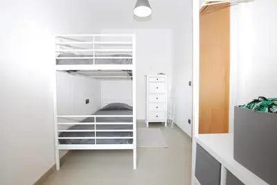 a bedroom with white bunk beds in a room at Petit niu · Petit niu · Apartamento AC - 3 min de la playa in Vilassar de Mar