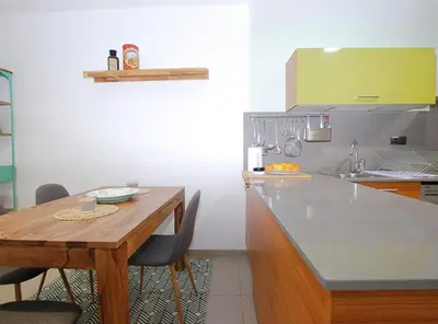a kitchen with a wooden table and a counter top at Petit niu · Petit niu · Apartamento AC - 3 min de la playa in Vilassar de Mar