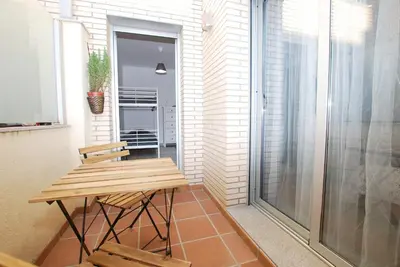 a small balcony with a wooden table and chairs at Petit niu · Petit niu · Apartamento AC - 3 min de la playa in Vilassar de Mar
