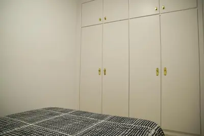 a white bedroom with a bed and white cabinets at Flat Barcelona in Barcelona
