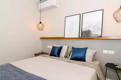 a bedroom with a bed with blue pillows at Sitges Spaces Deluxe Centre Apartment in Sitges
