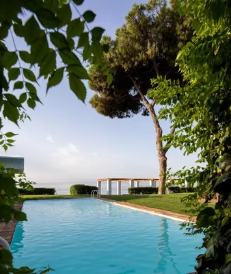 a swimming pool with a tree in the foreground at Villa Can Bagués in Mataró