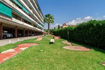 a park with a bench in the grass next to a building at Apartment Llavaneres I in Sant Andreu de Llavaneres