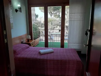 a bedroom with a bed with a purple blanket and a window at Habitaciones en Villa Coliving Casa Rural in San Fausto de Campcentellas