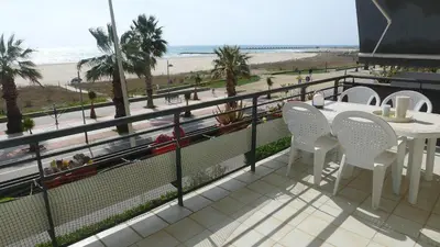 a balcony with a table and chairs and the beach at Casa Ana -Cubelles in Cubelles