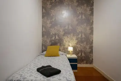 a bedroom with a bed with a yellow pillow on it at Nice Apartment in Barcelona