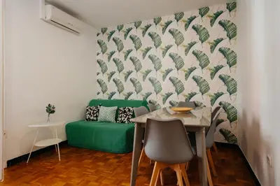 a living room with a table and a green couch at Nice Apartment in Barcelona