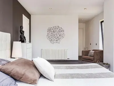 a bedroom with a bed and a chair at Architect modern design villa in Sitges Hills in Olivella