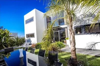 a house with a palm tree in front of it at Architect modern design villa in Sitges Hills in Olivella