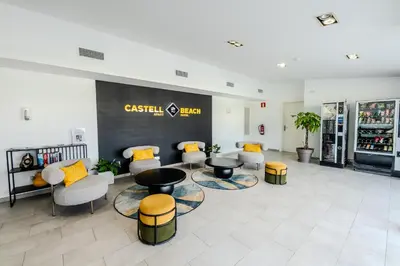 a waiting room with couches and tables in a building at Castell Beach Aparthotel in Castelldefels