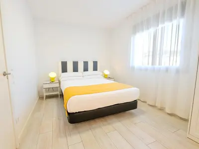 a bedroom with a bed and a window at Castell Beach Aparthotel in Castelldefels