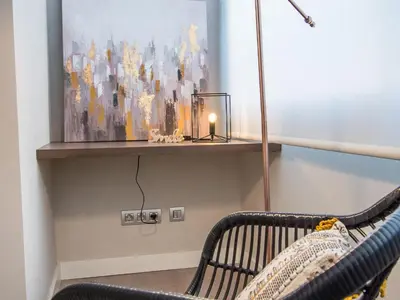 a bench in a room with a painting and a candle at Sitges Spaces Seaside Beach Flat- 4 Bedroom, 2 Bathroom, Terrace, Near Beach in Sitges