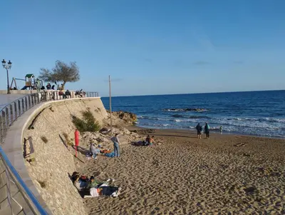 a group of people sitting on the beach at Sitges Spaces Seaside Beach Flat- 4 Bedroom, 2 Bathroom, Terrace, Near Beach in Sitges