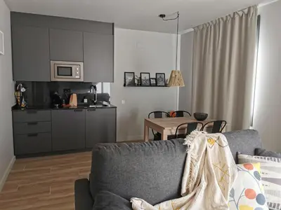 a kitchen and a living room with a couch and a table at Apartaments Agulles de Montserrat in Monistrol
