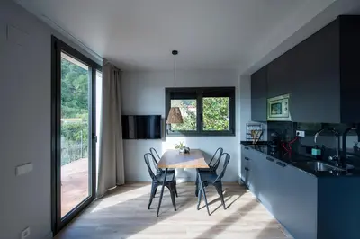 a kitchen with a table and chairs in a kitchen at Apartaments Agulles de Montserrat in Monistrol