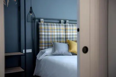 a bedroom with a bed with yellow and blue pillows at Apartaments Agulles de Montserrat in Monistrol