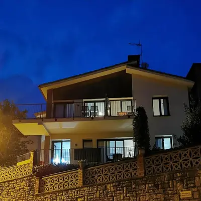 a house with a fence in front of it at night at Apartaments Agulles de Montserrat in Monistrol
