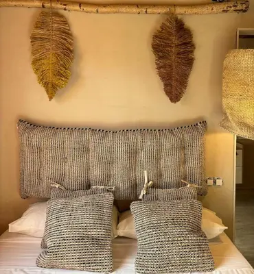 a bedroom with a headboard with leaves on the wall at Les Suites in Santa María de Palautordera