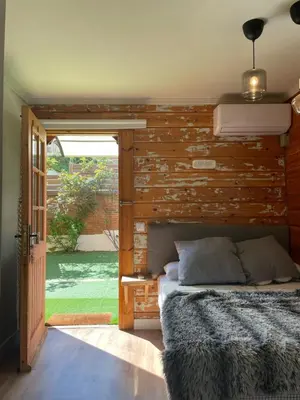 a bed in a room with a wooden wall at Les Suites in Santa María de Palautordera