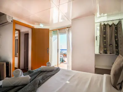 a bedroom with a large bed and a large window at Linda Vista Oasis Penthouse by Hello Homes Sitges in Sitges