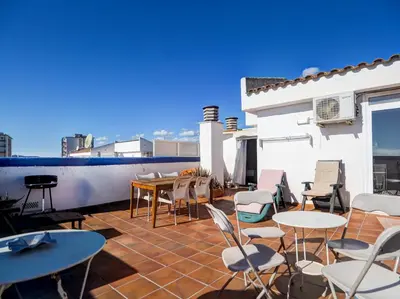 a patio with tables and chairs on a roof at Linda Vista Oasis Penthouse by Hello Homes Sitges in Sitges