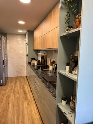a kitchen with wooden cabinets and a hardwood floor at Habitación Amaya 2 in Las Corts