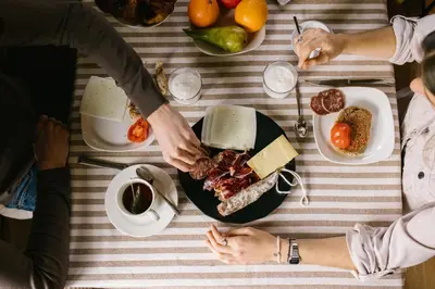 a group of people standing around a table with a plate of food at La Caseta del Munt in Castelltersol