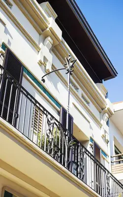 a building with a balcony with a black railing at Cal Peó B&B Cardedeu in Cardedeu