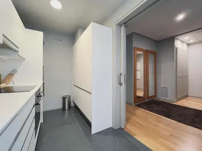 a kitchen with white cabinets and a hallway at Stay U-nique Apartments Rambla Catalunya II in Barcelona