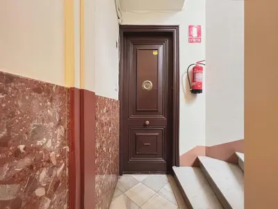 a brown door in a hallway with a fire extinguisher at Stay U-nique Apartments Rambla Catalunya II in Barcelona
