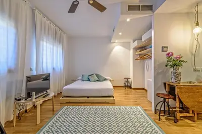 a bedroom with a bed and a tv and a desk at Tata's House, junto playa y Barcelona Centro in Masnou