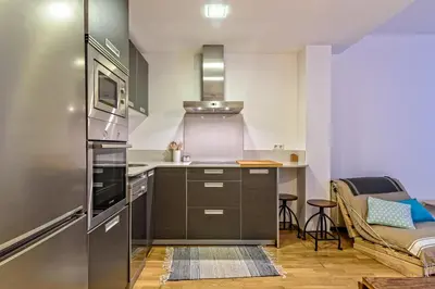 a kitchen with a stainless steel refrigerator and a table at Tata's House, junto playa y Barcelona Centro in Masnou