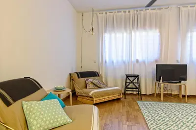 a living room with a couch and a tv at Tata's House, junto playa y Barcelona Centro in Masnou