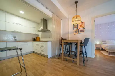 a kitchen and living room with a table and a bed at HomeHolidaysRentals Plume - Costa Barcelona in Pineda de Mar