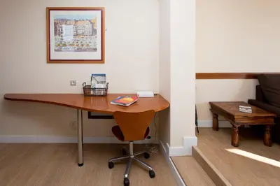 a desk in a room with a couch and a table at Gaudi penthouse with terrace views in Barcelona