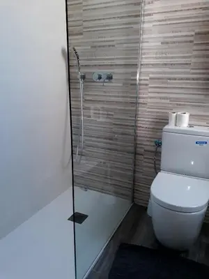 a bathroom with a toilet and a glass shower at Gaudi penthouse with terrace views in Barcelona