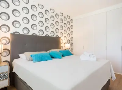 a bedroom with a large white bed with blue pillows at SITGES POOL & SEA TERRACE Luxury, comfort, unbeatable location in Sitges