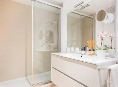 a white bathroom with a sink and a shower at SITGES POOL & SEA TERRACE Luxury, comfort, unbeatable location in Sitges