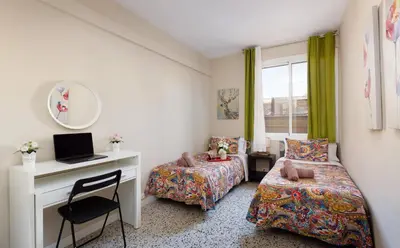 a bedroom with two beds and a desk with a computer at Mercat Sant Antoni 1 in Barcelona