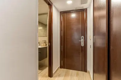a hallway with a wooden door in a bathroom at Aparthotel Centric in Castelldefels