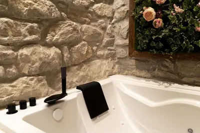 a bathroom with a bath tub with a black brush at Les Quingles in Calders