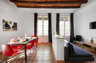 a living room with a table and red chairs at AB Gran de Gràcia in Barcelona