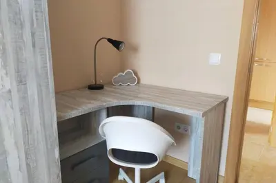 a desk with a white fan and a lamp at Apartamento para 5 personas frente al mar con piscina y parking in Cubelles