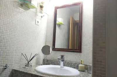 a bathroom with a sink and a mirror at Apartamento para 5 personas frente al mar con piscina y parking in Cubelles
