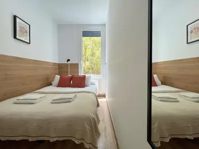 a bedroom with two beds and a mirror at Stay U-nique Apartments Urgell in Barcelona