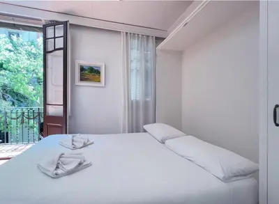 a white bedroom with a large white bed and a window at Stay U-nique Apartments Rogent in Barcelona