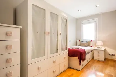 a white bedroom with a bed and a window at Stay U-nique Apartments Sardenya in Barcelona