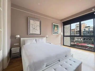 a bedroom with a large white bed and a large window at Stay U-nique Apartments Urquinaona in Barcelona